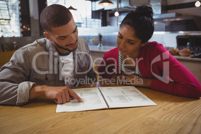 Young friends reading menu in cafe