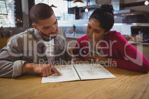 Young friends reading menu in cafe