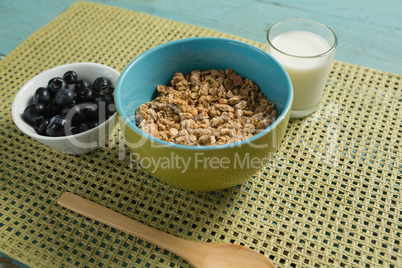 Bowl of cereals and blueberries with glass of yogurt for breakfast