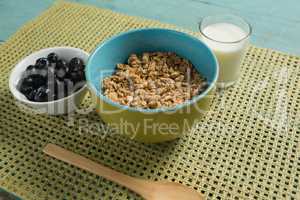 Bowl of cereals and blueberries with glass of yogurt for breakfast
