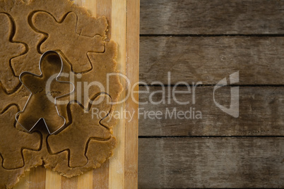 Directly above shot of gingerbread man pastry cutter on dough