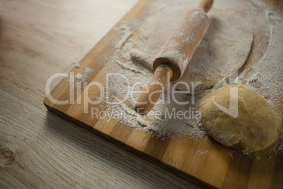 High angle view of pastry dough with rolling pin
