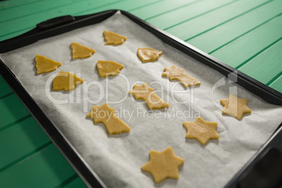 High angle view of various shape raw cookies in baking tray