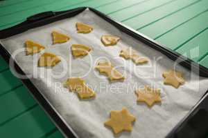 High angle view of various shape raw cookies in baking tray