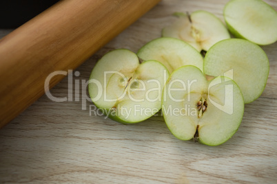High angle view of granny smith apple slices by rolling pin