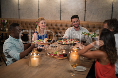 Friends passing food to each other while dining