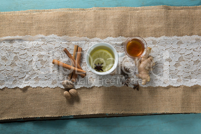 Overhead view of ginger tea with cinnamons on burlap