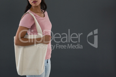 Mid section of young woman carrying shoulder bag