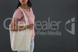 Mid section of young woman carrying shoulder bag