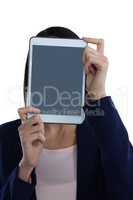 Businesswoman covering her face with digital tablet