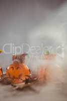 Jack o lantern containers over smoke on table during Halloween