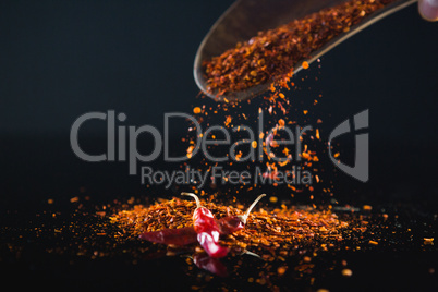 Red chilli flakes against black background