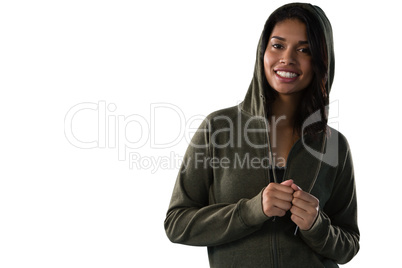 Smiling female athlete in hooded jacket