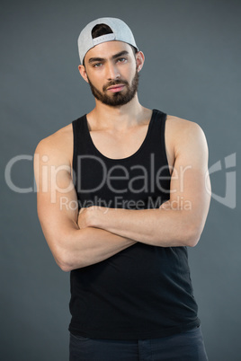 Handsome man posing with arms crossed against grey background