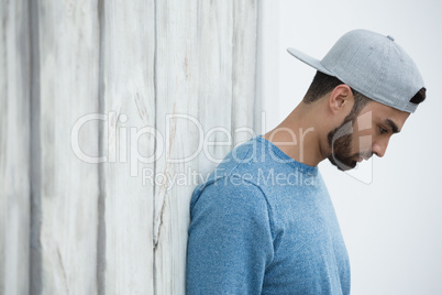 Man leaning on wooden wall