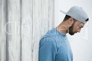 Man leaning on wooden wall