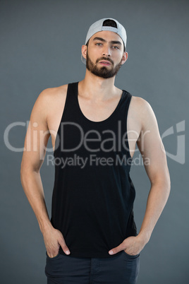 Handsome man posing with hands in pocket against grey background