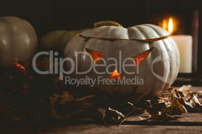 Jack o lanterns with autumn leaves on table