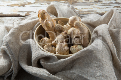 High angle view of gingers in bowl on burlap over table