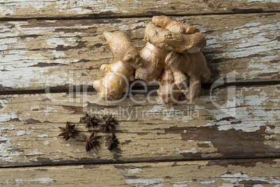 Overhead view of fresh gingers and star anise on weathered table