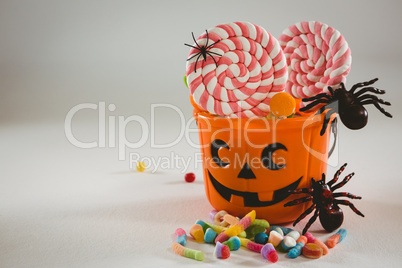 Bucket with candies and decoration over white background