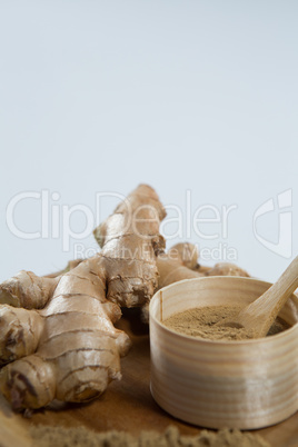 Close up of ginger and powder in wooden plate