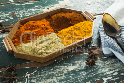 Various spice powder in wooden tray