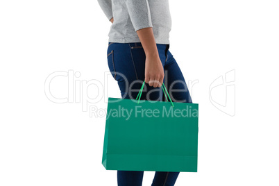 Mid section of woman holding green shopping bag