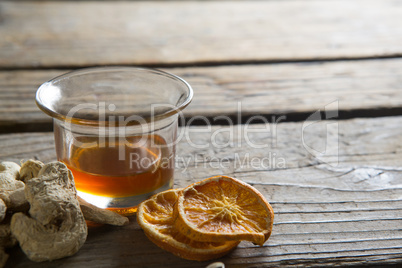 Tea cup with dried ginger and lemon slices on table