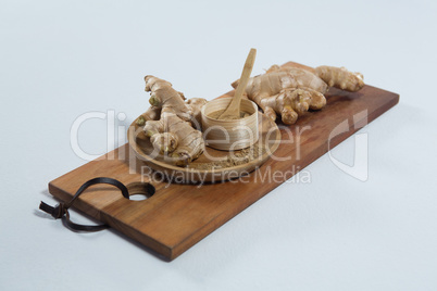 High angle view of organic gingers and powder on wooden serving board