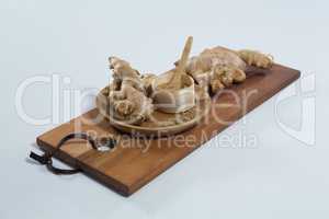 High angle view of organic gingers and powder on wooden serving board