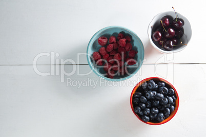 Overhead view of berries and cherries in bowls