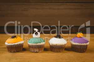 Cup cakes arranged on wooden table during Halloween