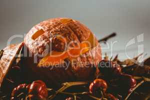 Close up of jack o lantern with small pumpkins and leaves