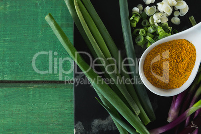 Scallions and turmeric powder on board