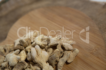 Dried gingers on wooden board over burlap