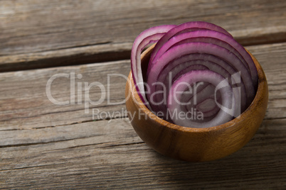 Onion slices in wooden bowl