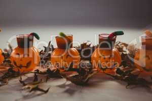 Food in jack o lantern containers with leaves during Halloween