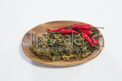 High angle view of dried kale with red chili pepper in wooden plate