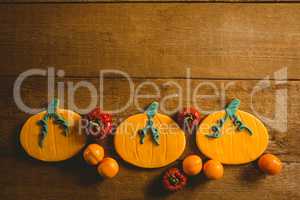Overhead view of cookies with candies and pumpkins on table