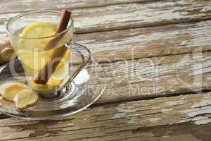 High angle view of cinnamon and lemon in ginger tea on weathered table