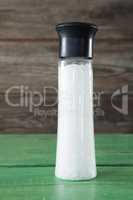 Close-up of white sea salt in shaker bottle