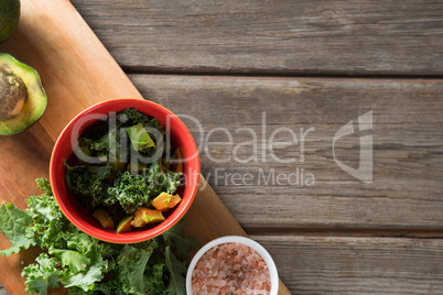 Fresh vegetable with cutting board at wooden table