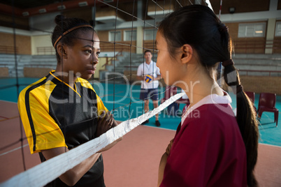 Female players standing with arms crossed and staring each other