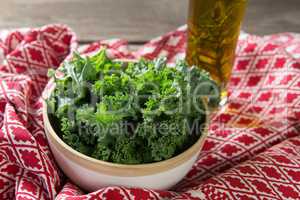 Fresh kale leaves with oil bottle and fabric