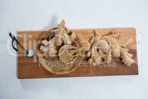 High angle view of fresh ginger and powder on wooden serving board