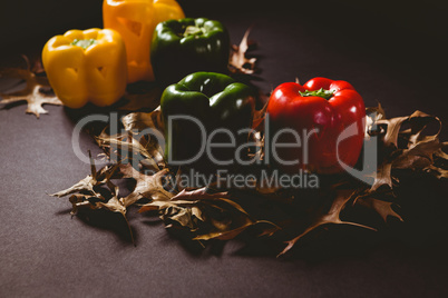 Carved bell pepper with autumn leaves on wooden table