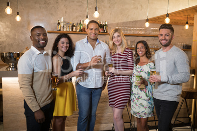 Happy friends standing with drinks in restaurant