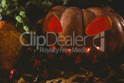 Jack o lantern with autumn leaves on table during Halloween