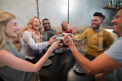 Happy friends toasting coffee